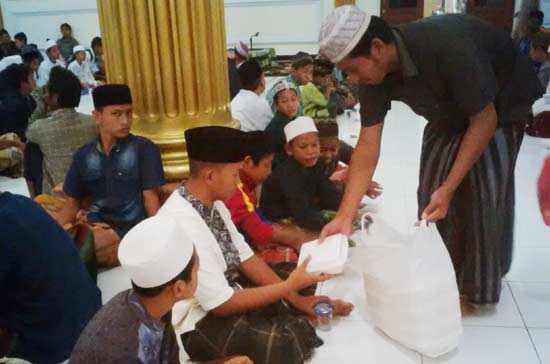 Sejumlah pengurus masjid agung Lamongan membagikan nasi bungkus dan takjil. (foto: haris/BANGSAONLINE)
