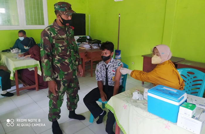 Babinsa Koramil 0811/06 Plumpang, Sertu Sumargono saat mengawal vaksinasi pelajar di SMPN 3 Plumpang.