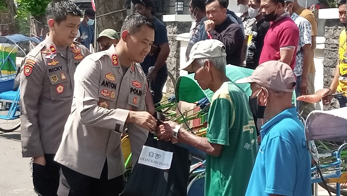 Kapolres Madiun AKBP Anton Prasetyo menyerahkan langsung bantuan sembako kepada para tukang becak. foto: HENDRO SUHARTONO/BANGSAONLINE