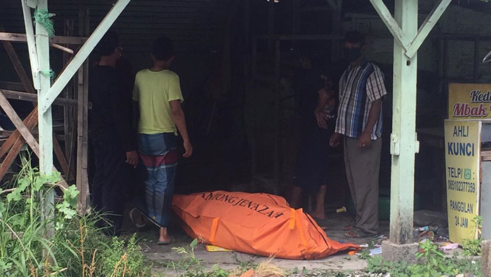 Petugas saat mengevakuasi jenazah pria tanpa identitas di bangunan bekas warung kopi di Jalan Banjarpoh, Sidoarjo.