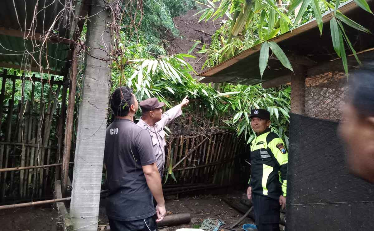 Petugas saat menunjukkan plengsengan yang ambrol akibat hujan deras di Kota Batu.