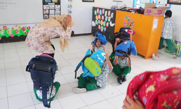 BERLINDUNG: Siswa KB-TK Al Muslim mengikuti simulasi gempa bumi, Rabu (4/3). foto: ist