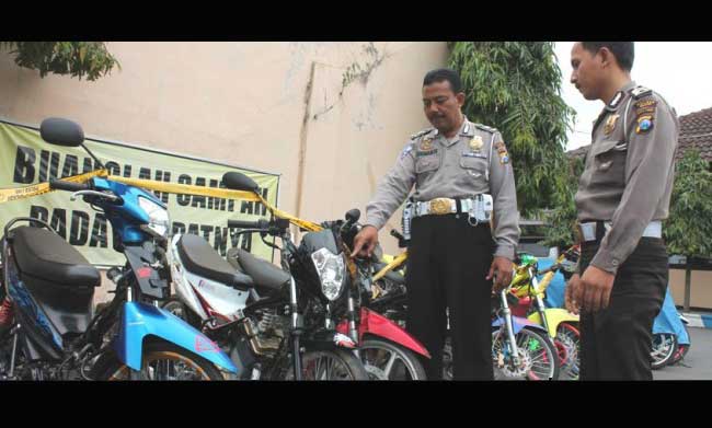 Petugas menunjukkan barang bukti motor yang disita. foto: zainal abidin/ BANGSAONLINE