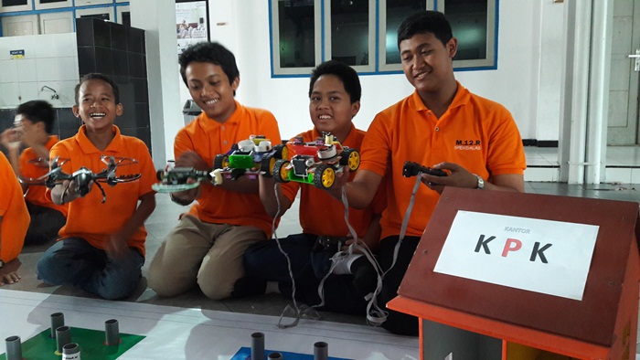 Tim Robotic SMP Muhammadiyah GKB sedang mensimulasikan Robot Penangkap Koruptor. Foto: SYUHUD/BANGSAONLINE