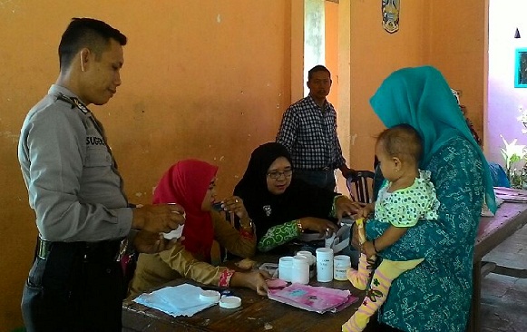 
Salah satu anggota polisi saat pantau kegiatan Posyandu.
.