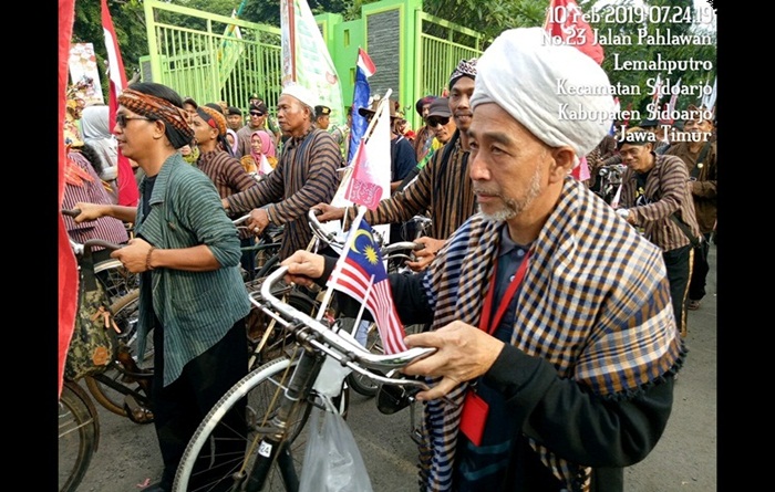 Salah satu peserta dari negara tetangga (Malaysia) tampak sedang menuntun sepeda onthelnya. 