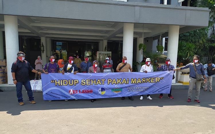 Dengan memakai masker merah putih, Wali Kota Risma foto bersama para awak media yang tergabung ke dalam Pokja Wartawan Pemkot Surabaya. (foto: YUDI A/ BANGSAONLINE).