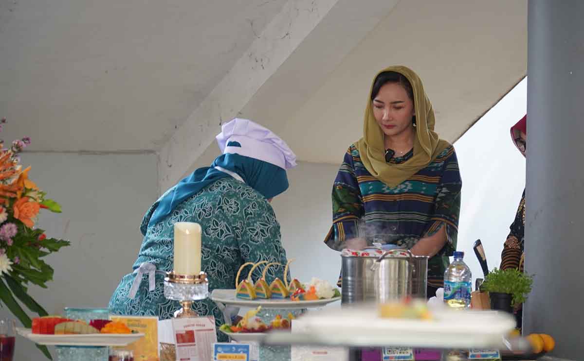 Pj Ketua TP PKK Nganjuk, Eka Haryati Taruna, saat memperhatikan proses pembuatan menu dengan bahan ikan.