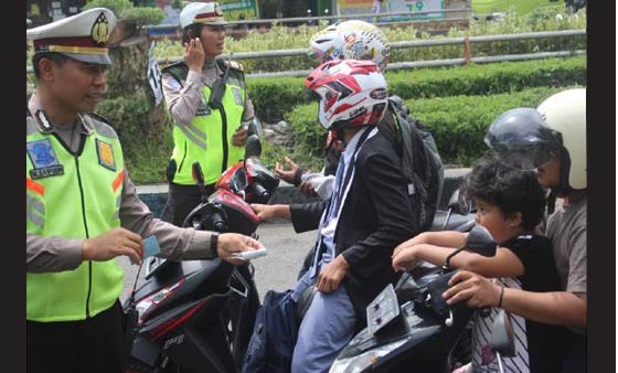 Polisi saat memeriksa satu per satu pengendara untuk diperiksa kelengkapan kendaraannya. 