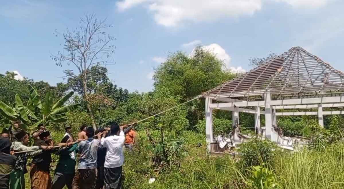 Puluhan warga Desa Winongan Kidul, Kecamatan Winongan, Kabupaten Pasuruan, ketika membongkar sebuah makam baru yang dibangun di belakang Masjid Serambi.