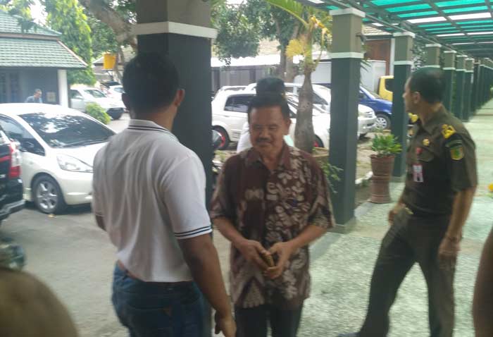 Tersangka kasus korupsi Jembatan Brawijaya Kota Kediri, Kasenan (baju batik) saat tiba di kantor Kejaksaan Negeri Kota Kediri. foto: ARIF K/ BANGSAONLINE