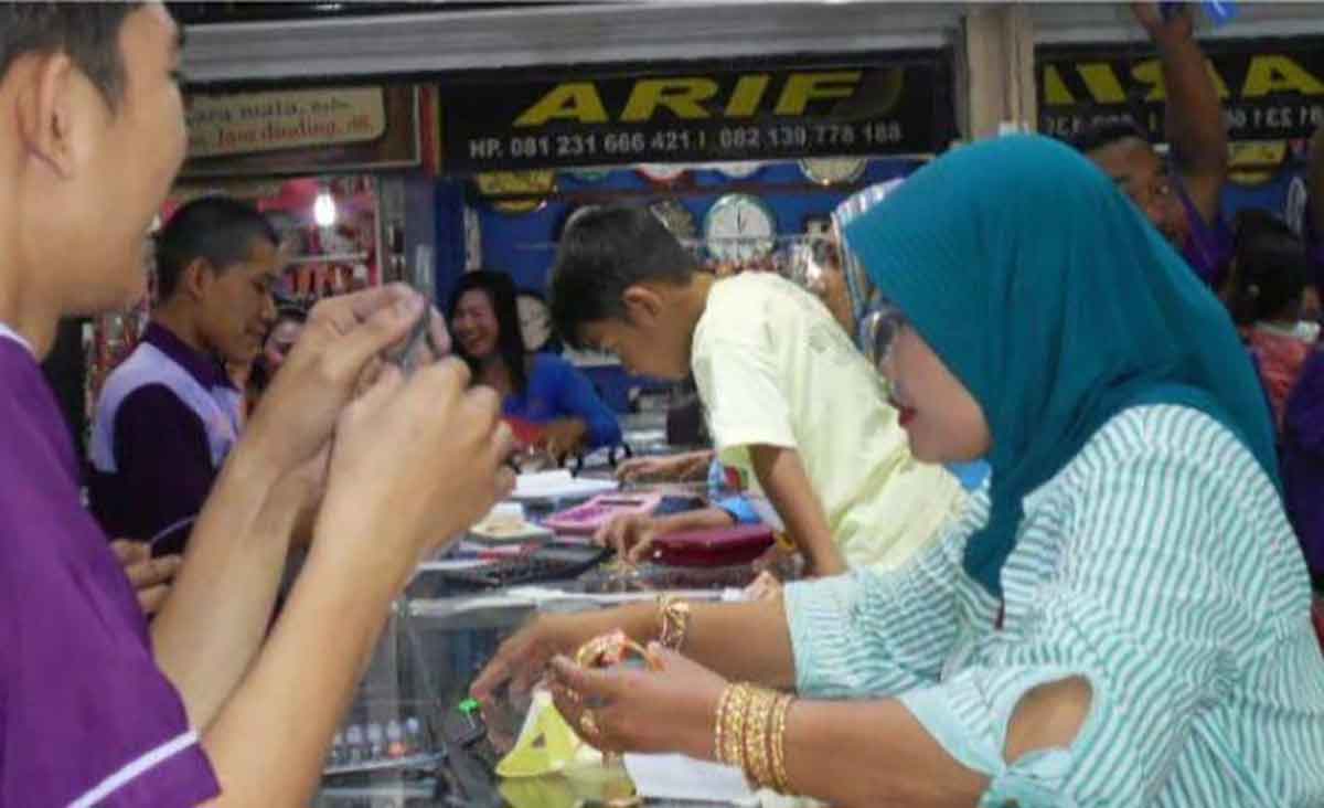 Karyawan toko emas di Lamongan saat melayani pembeli.