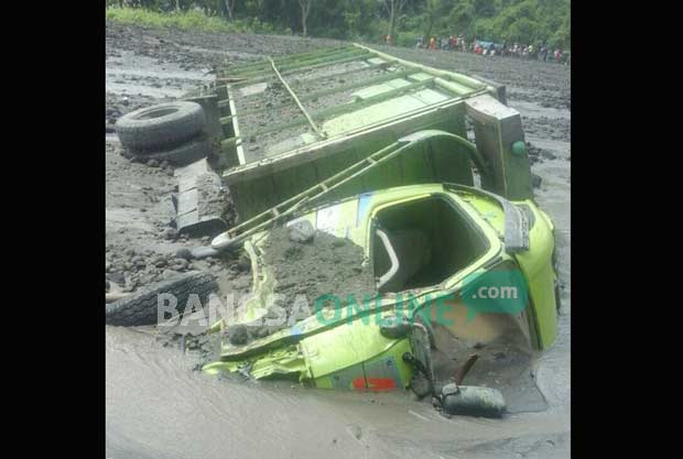 Salah satu truk penambang pasir yang terbawa arus banjir bandang di Kali Bladak. foto: AKINA/ BANGSAONLINE