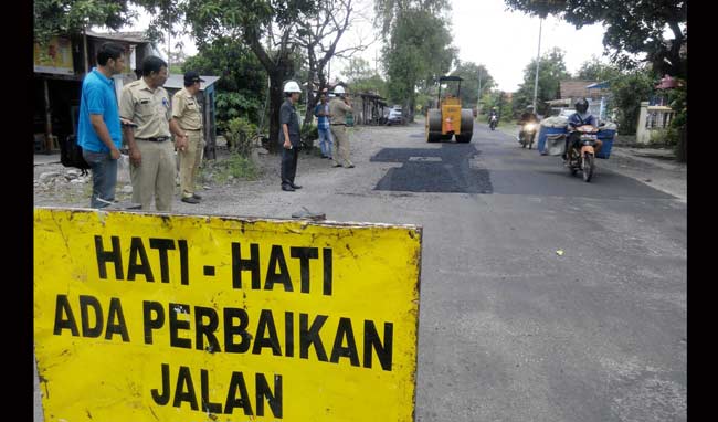 DITAMBAL: Perbaikan jalan rusak yang dilakukan PU Bina Marga Sidoarjo di ruas jalan Bulang-Prambon, beberapa bulan lalu. foto: ilustrasi/ MUSTAIN/ BANGSAONLINE