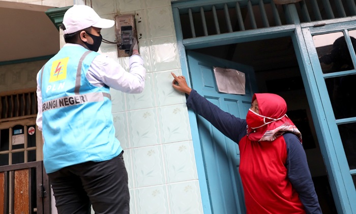 Petugas PLN saat mengecek meteran listrik warga.