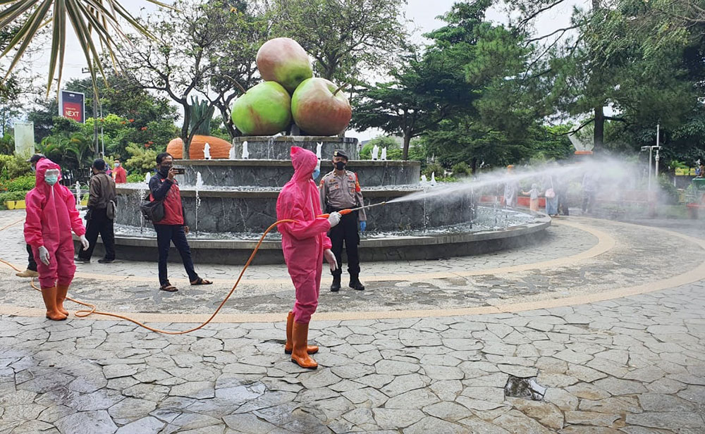 Petugas gabungan saat melakukan penyemprotan disinfektan di Alun-Alun Kota Wisata Batu (KWB).