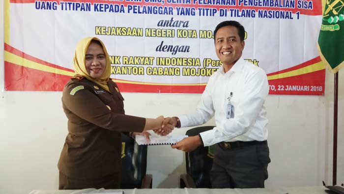 Kajari Kota Mojokerto Halila Rama Purnama dan Pinca BRI Mojokerto Lutfi Iskandar memantau pembayaran via BRI di kantor Kejari Mojokerto usai MoU perjanjian kerjasama penyediaan mesin EDC. Foto: YUDI EP/BANGSAONLINE