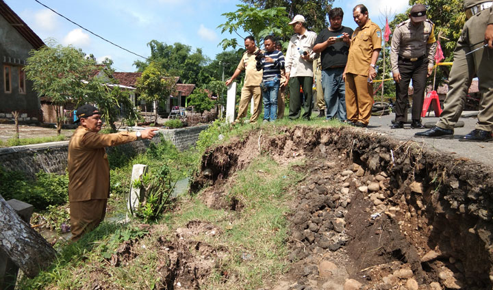 Wakil Bupati Nganjuk Marhaen Jumadi tampak sedang berdiri di pinggir tanggul yang longsor. Ia meminta segera dilakukan perbaikan secepatnya. foto: BAMBANG/ BANGSAONLINE