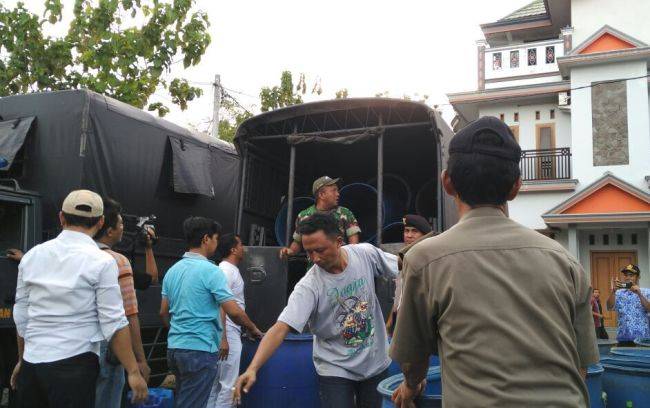 Petugas saat mengamankan barang bukti berupa ratusan drum arak. foto: SUWANDI/ BANGSAONLINE