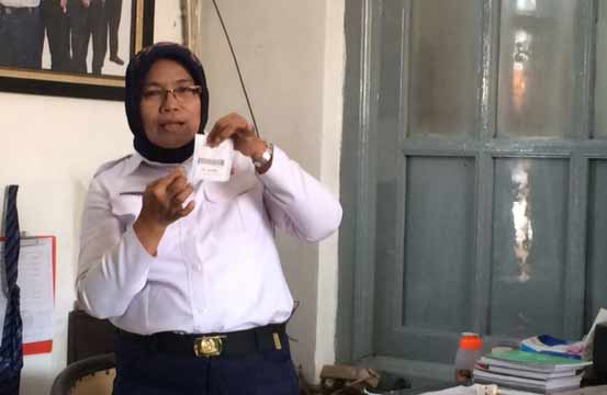 Staf khusus PT KAI saat menunjukkan tiket baru ekonomi jarak dekat yang ukurannya lebih kecil. foto: arif kurniawan/BANGSAONLINE