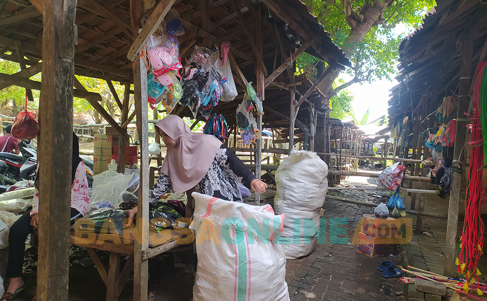 Endang Yati, pedagang sandal di Pasar Bringkoning saat menata dagangannya. Foto: MUTAMMIM/ BANGSAONLINE