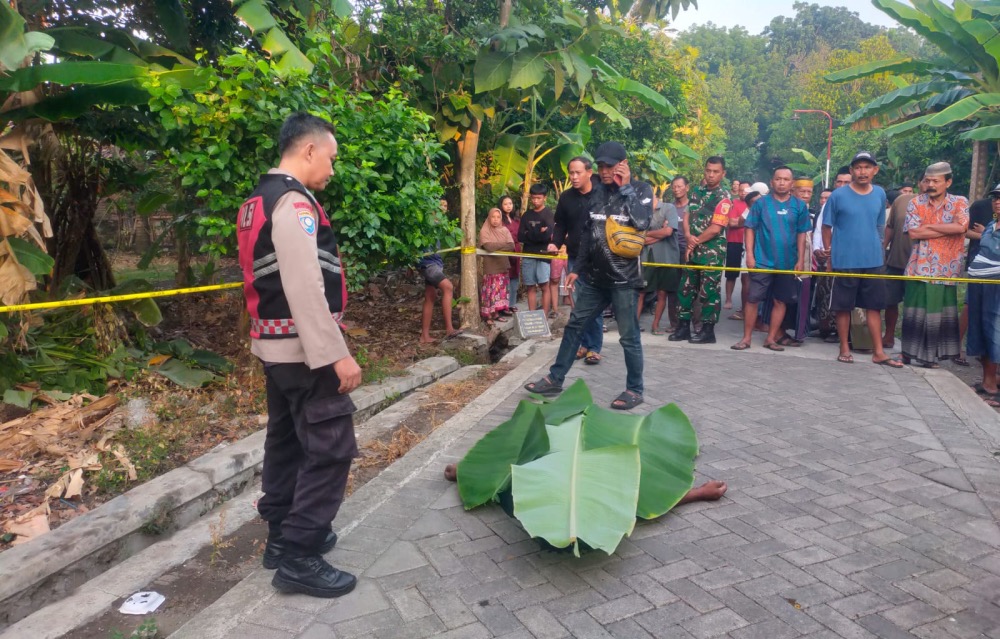 Petugas kepolisian melakukan olah TKP di lokasi penemuan mayat pria disabilitas yang diduga menjadi korban pembunuhan di Desa Kedungboto Kecamatan Porong. 