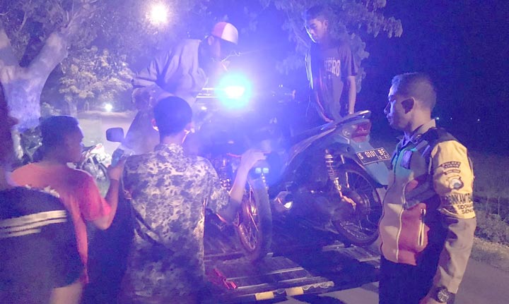 Petugas menaikkan dua motor hasil razia balap liar di jalan Desa Sendang, Kecamatan Senori menuju Desa Lajo Kidul, Kecamatan Singgahan.