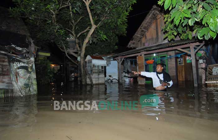 Kondisi banjir di Desa Kademangan, Kecamatan Mojoagung. Ketinggian air mencapai pusar orang dewasa. foto: RONY SUHARTOMO/ BANGSAONLINE