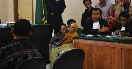 Nenek Asyani duduk terkulai saat mengikuti sidang lanjutan Kasus tuduhann pencurian kayu milik Perhutani. Foto: hadi prayitno/BangsaOnline.com