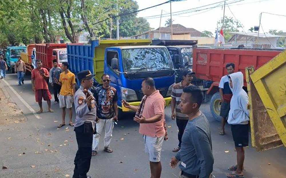 Para sopir dump truk saat unjuk rasa sambil memblokade jalan depan Mapolres Sumenep. Foto: Tribun