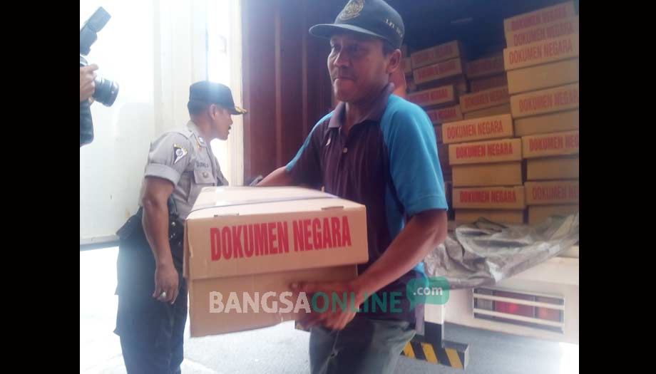 DOKUMEN NEGARA: Petugas saat menurunkan naskah Unas dengan dikawal pihak kepolisian. foto: eky nurhadi/ BANGSAONLINE 