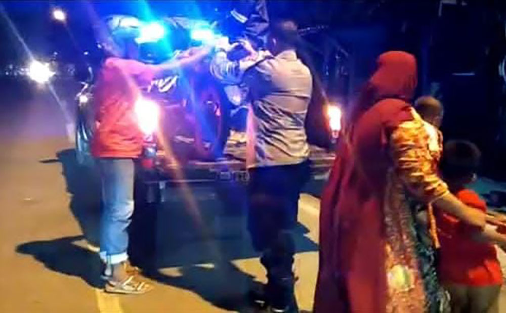 Petugas Polsek Manyar menaikkan motor penjual mie ayam karena bannya bocor. foto: ist.