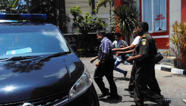 BURU-BURU: Munir bergegas masuk mobil Tipikor yang disiapkan, usai diperiksa kejaksaan. foto: nurqomar/ BANGSAONLINE