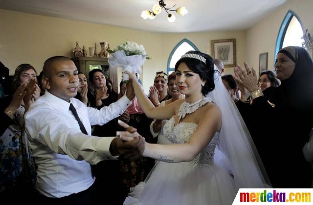 Mahmoud Mansour  dan Maral Malka saat merayakan upacara pernikahan bersama keluarga di Jaffa, selatan Tel Aviv, Israel (17/8). Pernikahan Mahmoud Mansour yang beragama Islam dan Malka yang berkeyakinan Yahudi ini menuai kemarahan warga Israel dari kelompok kanan. 