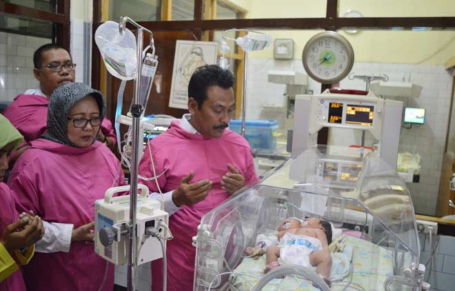 Wabup Gresik, Moh. Qosim ketika menjenguk bayi berkepala dua di RSUD Ibnu Sina. foto: SYUHUD/ BANGSAONLINE