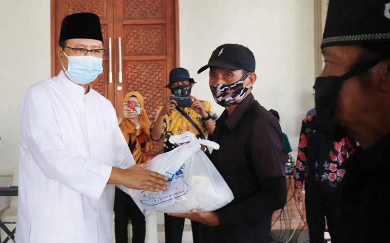 Wali Kota Pasuruan, Drs. H. Saifullah Yusuf (Gus Ipul) menyerahkan  secara simbolis paket sembako kepada salah satu tenaga harian lepas.
