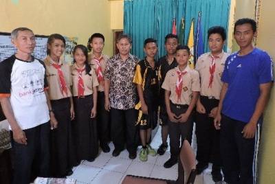Drs. Dasuki MM, (tengah baju batik) Kepala SMPN 8, saat berfoto bersama guru olahraga serta siswa peraih juara lomba O2SN. (foto: iwan irawan/BANGSAONLINE)