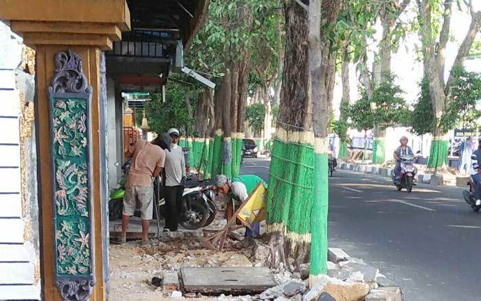 Pekerja saat membongkat trotoar. Foto: GUNAWAN/BANGSAONLINE