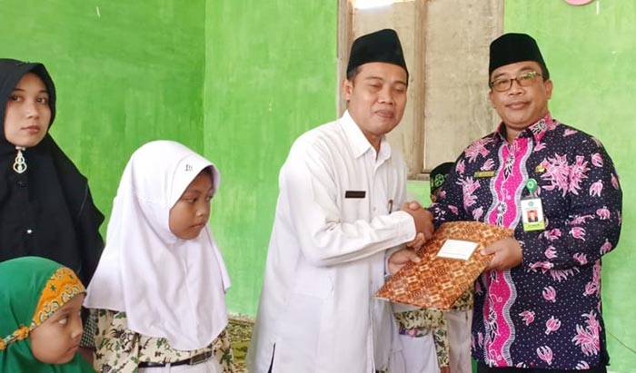Kepala Kemenag Tuban saat menyerahkan santunan kepada siswa-siswi kurang mampu.