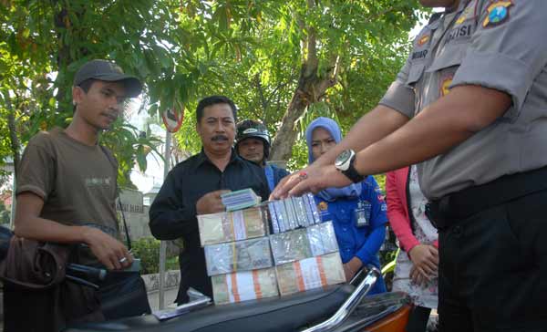 Salah satu jasa penukaran uang baru yang diperiksa oleh aparat kepolisian. (foto: rony suhartomo/BANGSAONLINE)