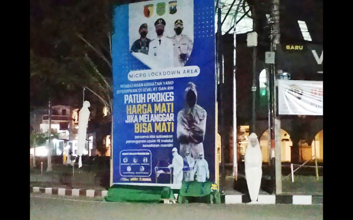 Baliho PPKM berikut pocong dan keranda mayat yang berada di depan Pasar Pon Trenggalek.