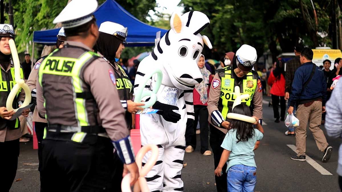 Petugas dari Satlantas Polres Gresik menyapa pengunjung CFD WEP sembari mengimbau untuk menaati aturan berlalu lintas. Foto: Ist