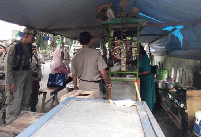 Petugas Satpol PP saat memperingatkan PKL yang berjualan di atas trotoar.