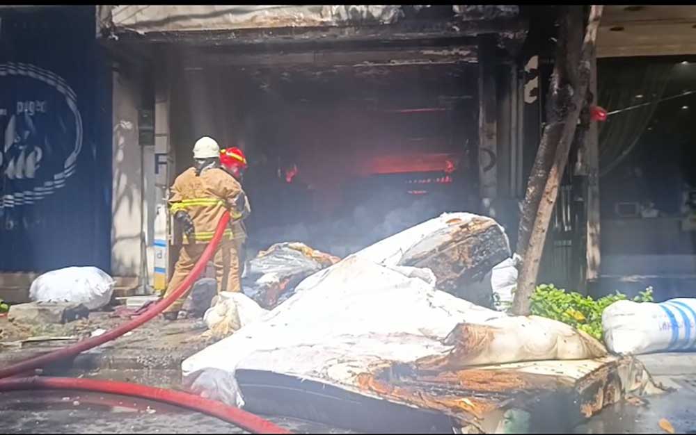 Petugas Damkar saat berjibaku menjinakkan api di toko mebel Sumber Rezeki, Jl. Kertajaya, Surabaya. 