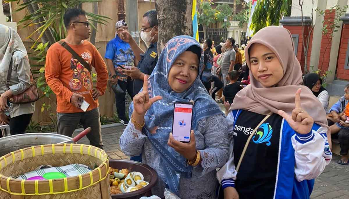 Pedagang nasi boran saat diperkenalkan aplikasi dari petugas Perumda Pasar Lamongan.