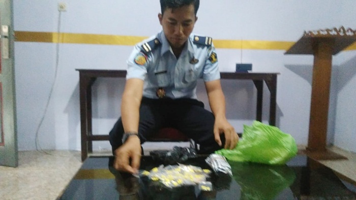 Petugas sedang menunjukkan pil dextro yang ditemukan.