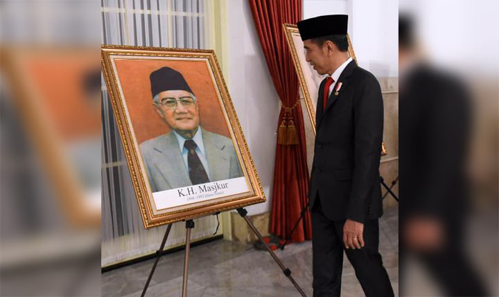 Presiden RI Joko Widodo melihat foto K.H. Masjkur dalam acara penganugerahan gelar pahlawan nasional, Jumat (8/11/2019). foto: istimewa/ bangsaonline.com