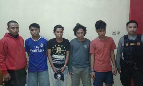 Empat tersangka begal diapit oleh Polisi.