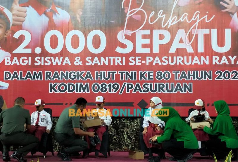 Danrem 083/BDJ  Kolonel INF Kohir didampingi Ketua Persit KCK Koorcab Rem 083 By. Nilam Kohir dan juga Dandim 0819 dan ibu Ketu Persit jabang Pasuruan saat memakaikan sepatu kepada siswa. Foto: M Andy Fachrudin/BANGSAONLINE