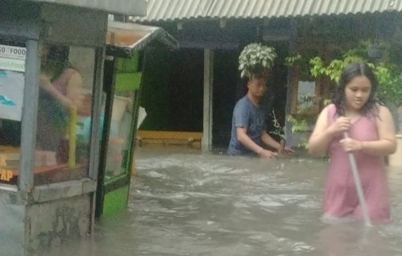 Warga Desa Tlogobendung, Kecamatan Gresik, Kabupaten Gresik, saat berada di luar rumah ketika banjir. Foto: SYUHUD/ BANGSAONLINE